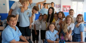 Una de las profesoras en prácticas de cursos anteriores posa con un grupo de alumnos